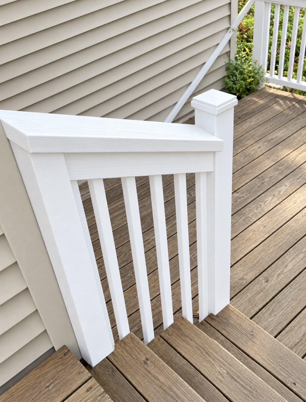 White railing and capped posts beside a wood deck