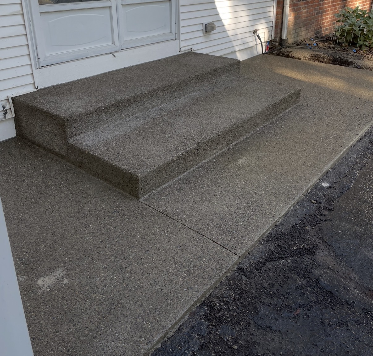 Concrete entry steps leading to a garage door