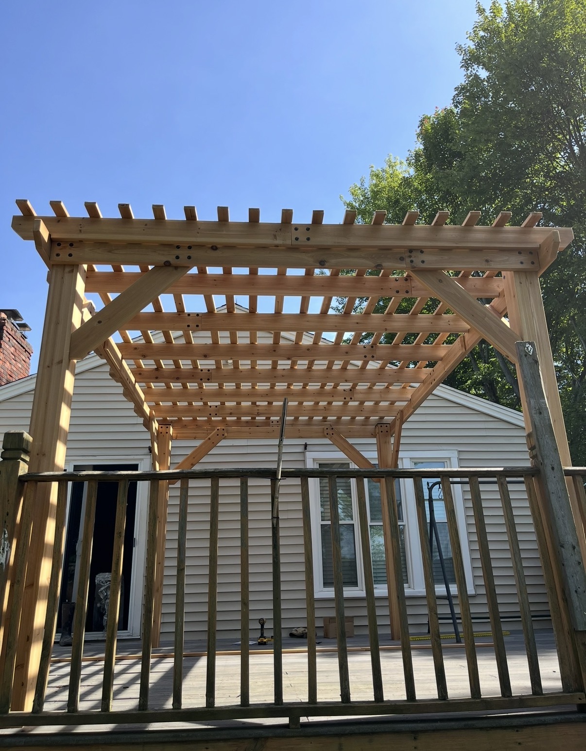 Our timber pergola project over a deck with dark metal railing